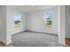 Bright, carpeted bedroom showcasing two windows with neighborhood views and white trim and walls at 349 N Post Oak Dr, Mooresville, IN 46158