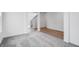 Upstairs hallway with neutral carpet, wood-style flooring, and a view of the white stairs and walls at 349 N Post Oak Dr, Mooresville, IN 46158