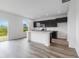Eat-in kitchen showcasing dark cabinets, stainless appliances, white island with marble countertops, and wood-style flooring at 349 N Post Oak Dr, Mooresville, IN 46158