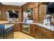 Home bar with granite counters, dark wood cabinets, and glass shelving at 5030 Nightshade Ln, Noblesville, IN 46062