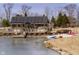 Stunning exterior view of the house, featuring a waterfront patio, deck, and sandy beach at 5030 Nightshade Ln, Noblesville, IN 46062