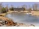 Gorgeous pond view with greenhouse, sandy beach area, and chairs for relaxing at 5030 Nightshade Ln, Noblesville, IN 46062