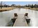 Scenic view of pond with wooden dock and chairs, surrounded by beautiful landscaping at 5030 Nightshade Ln, Noblesville, IN 46062