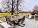 Deck with table, chairs, and umbrella overlooking backyard at 5299 Carnoustie Cir, Avon, IN 46123