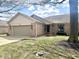 Charming brick home with an attached garage and well-manicured lawn under a partly cloudy sky at 5299 Carnoustie Cir, Avon, IN 46123