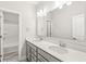 Modern bathroom featuring double sinks, a large mirror, and sleek gray vanity at 537 Steinbeck Pl, Carmel, IN 46032