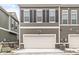Attached two-car garage in a modern townhome with dark shutters and stone accents, offering convenient parking at 537 Steinbeck Pl, Carmel, IN 46032