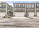 Three attached two-car garages in modern townhomes with neutral siding, offering convenient parking for residents at 537 Steinbeck Pl, Carmel, IN 46032
