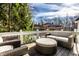 A cozy back deck area featuring a wicker couch and furniture with a view of the wooded backyard at 7341 Washington Blvd, Indianapolis, IN 46240