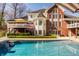 Rear exterior with a deck, swimming pool, brick facade, and plenty of windows for natural light at 7341 Washington Blvd, Indianapolis, IN 46240