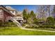 Spacious backyard with a deck, lush landscaping, fence, and a glimpse of a pool, perfect for outdoor gatherings at 7341 Washington Blvd, Indianapolis, IN 46240