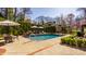 Inviting backyard pool area surrounded by lush greenery and a dining area, ideal for entertaining at 7341 Washington Blvd, Indianapolis, IN 46240