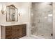 Luxurious bathroom showcasing marble shower, decorative mirror, wood vanity and sconce lighting at 7341 Washington Blvd, Indianapolis, IN 46240
