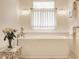 Bright bathroom featuring a soaking tub, soft lighting, and a window at 7341 Washington Blvd, Indianapolis, IN 46240