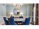 Formal dining room with designer chandelier, wainscoting and blue upholstered chairs at 7341 Washington Blvd, Indianapolis, IN 46240