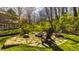 Stone fire pit area with Adirondack chairs, surrounded by lush landscaping and mature trees at 7341 Washington Blvd, Indianapolis, IN 46240