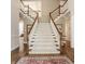 Elegant foyer featuring a grand staircase with white risers, wooden handrail, and hardwood floors at 7341 Washington Blvd, Indianapolis, IN 46240