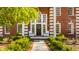 Inviting front entrance with a wreath on the door and decorative plants flanking the stone pathway at 7341 Washington Blvd, Indianapolis, IN 46240