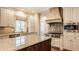 Well-lit kitchen with a large island, stainless steel appliances, and custom range hood at 7341 Washington Blvd, Indianapolis, IN 46240