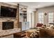 Inviting living room features a brick fireplace with mounted television and custom built-in shelving at 7341 Washington Blvd, Indianapolis, IN 46240