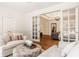 Bright living room showcasing hardwood floors, white sofas, and french doors leading to a stunning chandelier at 7341 Washington Blvd, Indianapolis, IN 46240