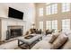 Cozy living room showcases a stone fireplace, mounted television, and windows with abundant natural light at 7341 Washington Blvd, Indianapolis, IN 46240