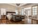 Spacious main bedroom with sitting area, tray ceiling, and hardwood floors at 7341 Washington Blvd, Indianapolis, IN 46240