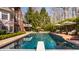 Backyard swimming pool adjacent to brick home, with umbrellas and lounge chairs for relaxing by the water at 7341 Washington Blvd, Indianapolis, IN 46240