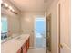 Bathroom with double sinks, wood cabinets, and a view into a bedroom at 10723 Pokagon Way, Indianapolis, IN 46239