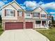 Two-story house with beige siding and red garage doors at 10723 Pokagon Way, Indianapolis, IN 46239