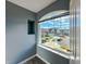 Large window showcases a picturesque neighborhood view from a room with gray walls at 10723 Pokagon Way, Indianapolis, IN 46239