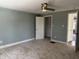 Bedroom with neutral carpet, a ceiling fan, and view to another room through doorway at 2029 W 60Th St, Indianapolis, IN 46228