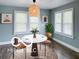 Cozy dining area featuring a round table, modern lighting, and natural light from the surrounding windows at 2029 W 60Th St, Indianapolis, IN 46228