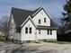 View of home's back exterior featuring white siding, a new roof, and a concrete driveway at 2029 W 60Th St, Indianapolis, IN 46228