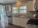 Bright kitchen featuring stainless steel dishwasher and sink, granite countertops, and white cabinets at 2029 W 60Th St, Indianapolis, IN 46228