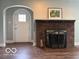 Inviting living room showcasing a brick fireplace and doorway with hardwood floors at 2029 W 60Th St, Indianapolis, IN 46228