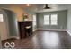 Open living room with brick fireplace, hardwood floors, natural light, and a ceiling fan at 2029 W 60Th St, Indianapolis, IN 46228