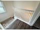 A staircase descends into a room with wood-look flooring, and a window providing natural light at 2029 W 60Th St, Indianapolis, IN 46228