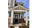 Inviting front porch with brick accents, white columns, and a stylish black front door at 2322 Dixon Creek Dr, Whitestown, IN 46075