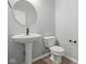 Contemporary half bath featuring a pedestal sink with a round mirror and a modern toilet at 4195 Douro Trl, Westfield, IN 46062