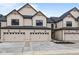 Modern townhome featuring light beige siding, black trim, and individual garages at 4195 Douro Trl, Westfield, IN 46062