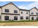 Back exterior view of the townhome featuring black frame windows, grass, and AC units at 4195 Douro Trl, Westfield, IN 46062