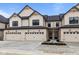 Modern townhome featuring light beige siding, black trim, and individual garages at 4195 Douro Trl, Westfield, IN 46062