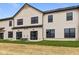 Back exterior view of the townhome featuring black frame windows, grass, and AC units at 4195 Douro Trl, Westfield, IN 46062