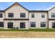 Back exterior view of the townhome featuring black frame windows, grass, and AC units at 4195 Douro Trl, Westfield, IN 46062