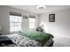 Bedroom with two windows, green bedding and night stand at 453 Gathering Ln, Greenwood, IN 46143