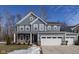 Two-story gray house with white trim, three-car garage, and landscaping at 453 Gathering Ln, Greenwood, IN 46143