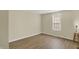 This empty bedroom contains a window, new floors, and a small lamp at 4632 Normal Ave, Indianapolis, IN 46226