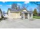 Charming yellow home featuring a spacious driveway and quaint, decorative front porch at 4632 Normal Ave, Indianapolis, IN 46226