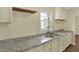 The kitchen area features a stainless steel sink with gray and white granite counters and white cabinets at 4632 Normal Ave, Indianapolis, IN 46226